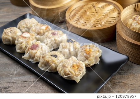 Assorted chinese dim sum dumpling on the plate with bamboo wooden basket bowl on wooden table 120978957