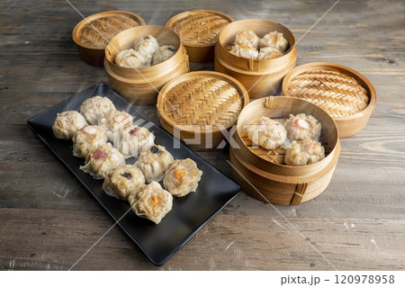 Assorted chinese dim sum dumpling on the plate with bamboo wooden basket bowl on wooden table 120978958