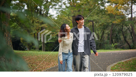 Asian couple hug, laugh and walk at park for holiday, funny joke or sightseeing together. Japanese man, woman and embrace outdoor on date for romantic connection, love or happy to travel on vacation 120979025