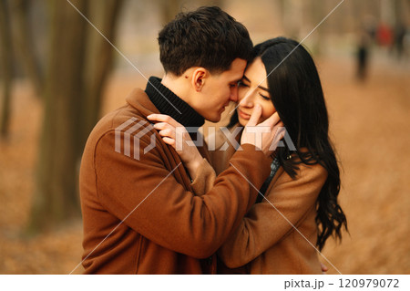 Young couple in love walking in the park on a autumn day. Enjoying time together. Young couple in love walking in the park on a autumn day. Enjoying time together. 120979072