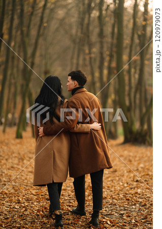 Young couple in love walking in the park on a autumn day. Enjoying time together. Young couple in love walking in the park on a autumn day. Enjoying time together. 120979073