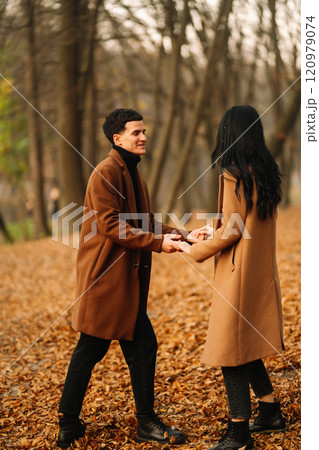 Young couple in love walking in the park on a autumn day. Enjoying time together. Young couple in love walking in the park on a autumn day. Enjoying time together. 120979074