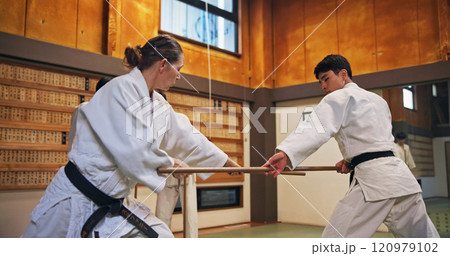 Dojo, class and strike partner at Aikido training in gym with wood sword Japanese martial arts and fight exercise in studio. Learning, sport and bamboo weapon with people and practice for defence Dojo, class and strike partner at Aikido training in gym with wood sword Japanese martial arts and fight exercise in studio. Learning, sport and bamboo weapon with people and practice for defence 120979102
