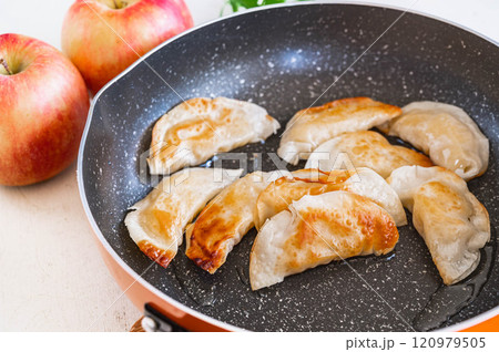 揚げ焼きする餃子のアップルパイ風 揚げ焼きする餃子のアップルパイ風 120979505