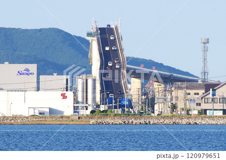 中海に浮かぶ大根島の岸辺から望遠レンズで撮影した江島大橋(通称ベタ踏み坂)の松江方面側の急勾配の写真 中海に浮かぶ大根島の岸辺から望遠レンズで撮影した江島大橋(通称ベタ踏み坂)の松江方面側の急勾配の写真 120979651