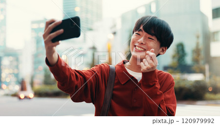 Japanese man, selfie and smile in street for social media, post or memory as university student. Male person, outdoor and city with photography, pride or finger heart for networking or online profile 120979992