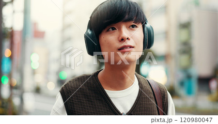 Japanese man, thinking and outdoor with headphones, vision and pride in city street or metro. Male person, happiness and music as engineering student in university with planning, tourism and commute 120980047