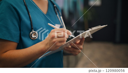 Hands, person and surgeon writing on clipboard at clinic for medical referral, diagnosis report and insurance. Nurse, document and healthcare of checklist, prescription and surgery schedule in Japan 120980056