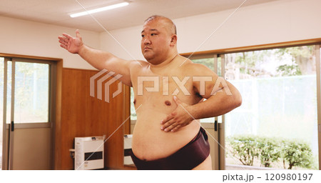 Athlete, training and exercise for sumo, sports and fitness with preparation, skill and wrestling in ring. Japanese man, fighter and wrestler in dohyo for culture, workout and technique with warm up 120980197