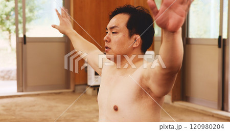 Man, training and exercise for sumo, fitness and exercise with preparation, stretching and technique in Japan. Athlete, fighter and sports in dohyo for practice, workout and wrestling with warm up 120980204