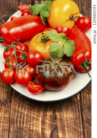 Ripe tomatoes on rustic wooden background. 120980593