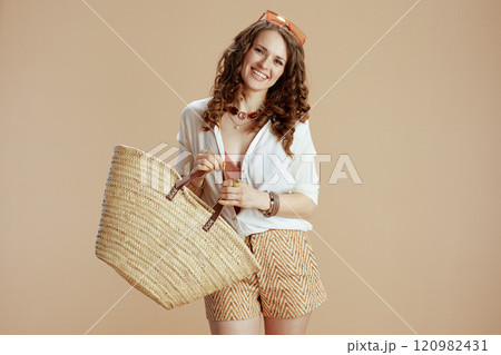 happy 40 years old woman in blouse and shorts isolated on beige 120982431