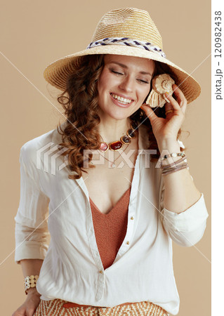 smiling trendy housewife in blouse and shorts on beige smiling trendy housewife in blouse and shorts on beige 120982438