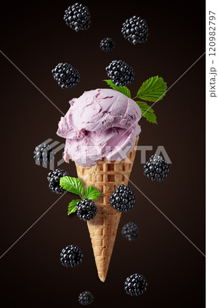 Blackberry ice cream with falling berries on a dark background. 120982797