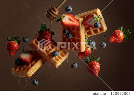 Waffles with blueberries, strawberries, and honey. Waffles with blueberries, strawberries, and honey. 120982802