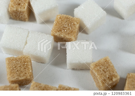Cubes of unrefined brown demerara sugar and white refined beet sugar. Cubes of unrefined brown demerara sugar and white refined beet sugar. 120983361