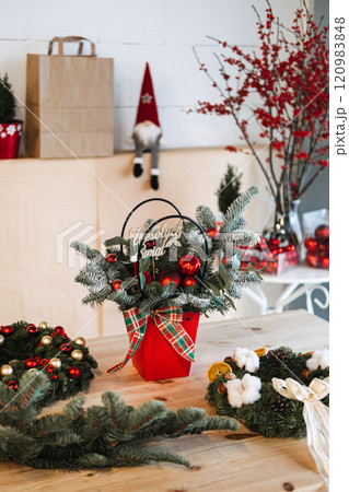 Rustic holiday Christmas tree and centerpiece with plaid ribbon, frosted greenery, and red accents in a vibrant pot. Perfect for cozy farmhouse Christmas decor. Rustic holiday Christmas tree and centerpiece with plaid ribbon, frosted greenery, and red accents in a vibrant pot. Perfect for cozy farmhouse Christmas decor. 120983848
