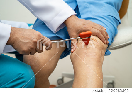 Asian doctor use hammer knock senior woman patient to check knee reflex, nerve and muscle in hospital. Asian doctor use hammer knock senior woman patient to check knee reflex, nerve and muscle in hospital. 120983860