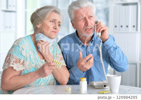 An elderly couple is sick and takes medication at home An elderly couple is sick and takes medication at home 120984205