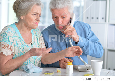 An elderly couple is sick and takes medication at home 120984261
