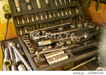 Plastic tool box with essential tools for car repair in an auto repair shop Plastic tool box with essential tools for car repair in an auto repair shop 120984349