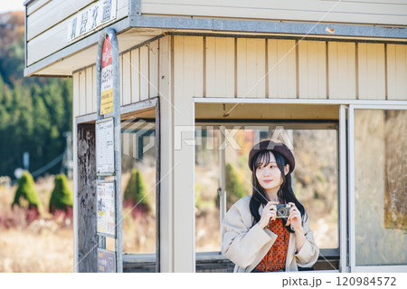 バス停でバスを待っている時間にカメラで写真を撮っている女性 撮影協力・羽後交通 バス停でバスを待っている時間にカメラで写真を撮っている女性 撮影協力・羽後交通 120984572