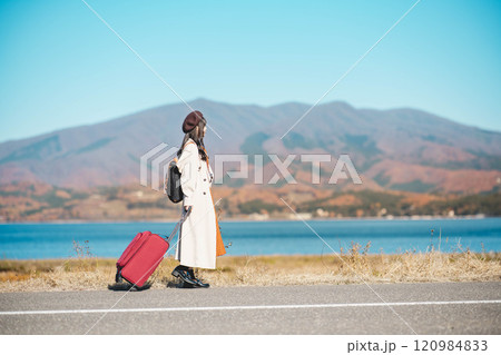 女子旅 キャリーバックを持って青空のもと歩いている若い女性 女子旅 キャリーバックを持って青空のもと歩いている若い女性 120984833