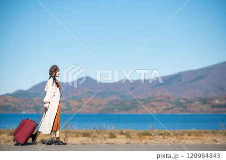 女子旅 キャリーバックを持って青空のもと歩いている若い女性 女子旅 キャリーバックを持って青空のもと歩いている若い女性 120984843