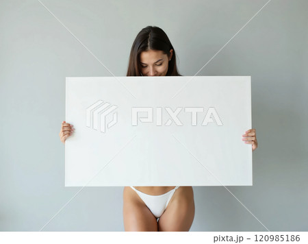Minimalist composition of a woman holding a blank white board in a bright setting, perfect for mockups and branding visuals 120985186