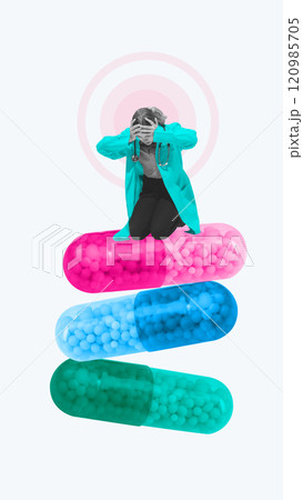 Contemporary art collage. Distressed doctor in medical attire kneels on stack of oversized capsules, highlighting emotional weight of healthcare challenges. 120985705