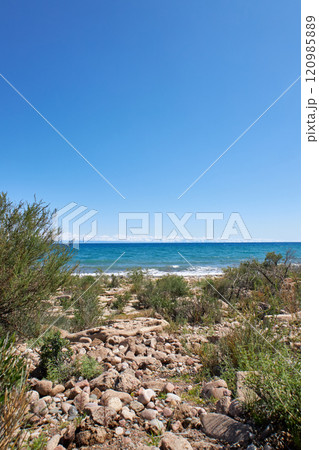 Wild beach, stone coast of southern shore of Lake Issyk-Kul, summer Kyrgyzstan 120985889