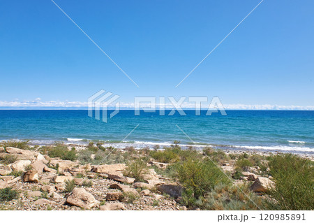 Stone coast of southern shore of Lake Issyk-Kul, summer vacation in Kyrgyzstan 120985891