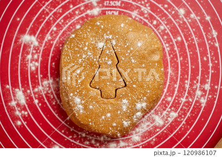 Christmas tree shape cut out in gingerbread dough Christmas tree shape cut out in gingerbread dough 120986107