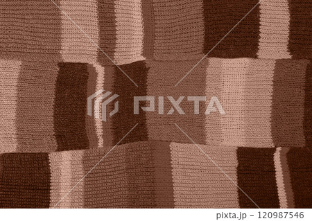 Demonstrating the colors of 2025 - Mocha Mousse. Knitted brown background. Large knitted fabric with a pattern. Close-up of a knitted blanket. Color concept. Demonstrating the colors of 2025 - Mocha Mousse. Knitted brown background. Large knitted fabric with a pattern. Close-up of a knitted blanket. Color concept. 120987546
