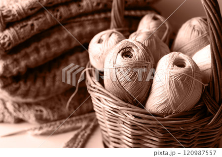 Yarn threads in basket for knitting warm clothes with knitting needles and finished yarn products, knitting hobby. Demonstrating the colors of 2025 - Mocha Mousse. Yarn threads in basket for knitting warm clothes with knitting needles and finished yarn products, knitting hobby. Demonstrating the colors of 2025 - Mocha Mousse. 120987557