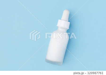 A frosted white dropper bottle on a pastel blue background A frosted white dropper bottle on a pastel blue background 120987761