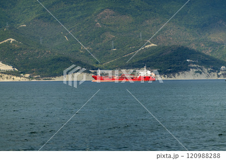 Sea freighter sailing in the middle of the ocean with big waves Sea freighter sailing in the middle of the ocean with big waves 120988288