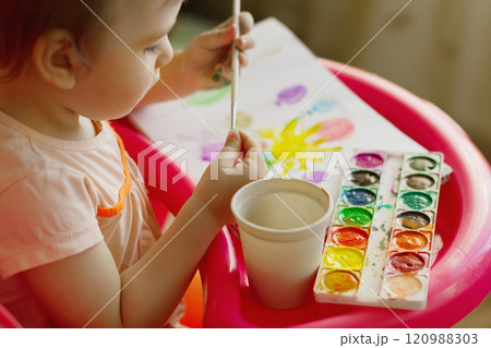 Hands of little kid 4-year-old Caucasian girl holds brush for drawing watercolor paints Hands of little kid 4-year-old Caucasian girl holds brush for drawing watercolor paints 120988303