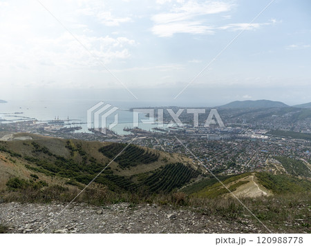 Panoramic view of Novorossiysk City and Tsemess Bay at sunrise. Morning cityscape of large port at Black Sea coast in Russia Panoramic view of Novorossiysk City and Tsemess Bay at sunrise. Morning cityscape of large port at Black Sea coast in Russia 120988778