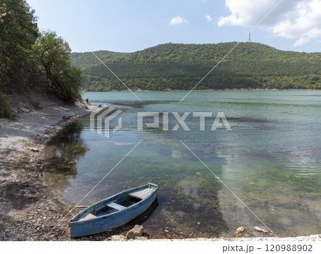 Small wooden boats of multiple colors moored on the shore of Lake Abrau 120988902