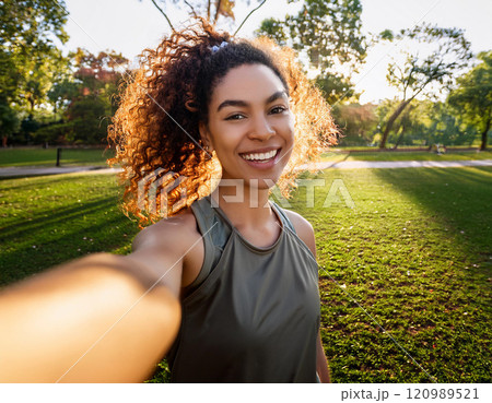 Young Woman Taking a Candid Selfie at Golden Hour in a Park 120989521