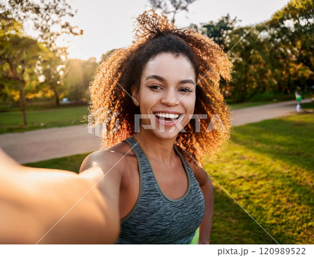 Young Woman Taking a Candid Selfie at Golden Hour in a Park 120989522