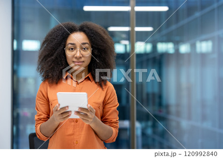 Young woman businesswoman using a tablet in a modern office. The technology-savvy professional confidently engages with the digital device, showcasing versatility and innovation in her work. Young woman businesswoman using a tablet in a modern office. The technology-savvy professional confidently engages with the digital device, showcasing versatility and innovation in her work. 120992840