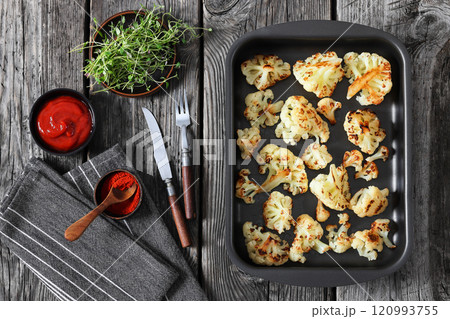 oven baked cauliflower florets in a baking tray 120993755