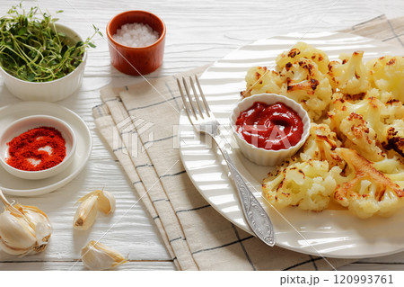 fried cauliflower florets on white plate, top view 120993761