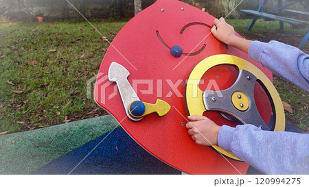 Large children's sensory toys on the playground and the child who plays with them. Concept of development of fine motor skills, Montesori for children outdoors Large children's sensory toys on the playground and the child who plays with them. Concept of development of fine motor skills, Montesori for children outdoors 120994275