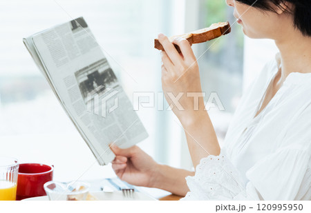 食事中に新聞を読む女性 食事中に新聞を読む女性 120995950