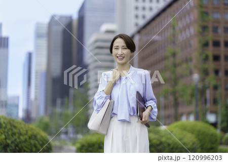 オフィス街で手帳を手に持つビジネスウーマンのポートレート 120996203