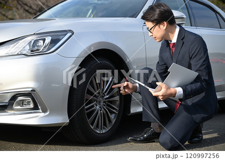 車の傷を確認するビジネスマン 120997256