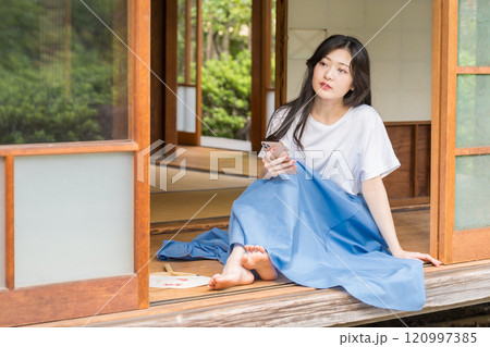 古民家の縁側でスマホを眺めてる若い女性 ネットショッピング- 古民家の縁側でスマホを眺めてる若い女性 ネットショッピング- 120997385